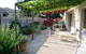 Un jardin facile d’entretien, une terrasse ombragée pour les repas, un espace BBQ dissimulé derrière les murs colorés